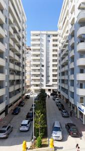 a parking lot with cars parked in front of tall buildings at Alrei Apartment in Vlorë