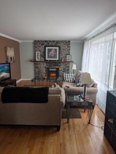 a living room with two couches and a fireplace at St Andrews Guest Home in St. John's