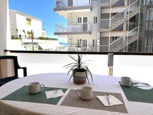 a table with two cups and napkins on a balcony at 3 Bed Flat - Sleeps 5 - Wifi in Bellreguart