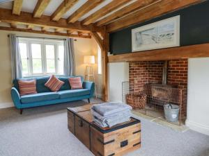 a living room with a blue couch and a fireplace at Gayton Stables in Wirral