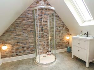a shower in a bathroom with a brick wall at Gayton Stables in Wirral +48 photos