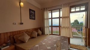 a bedroom with a bed and a large window at Red Cherry Homestay, Nokdara in Lava