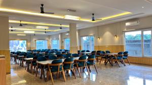 a conference room with tables and chairs and windows at Hill Turn Corbett in Rāmnagar +136 photos
