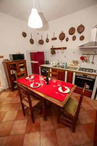 a kitchen with a wooden table with a red table cloth at Cristallo apartment in Ravenna +11 photos