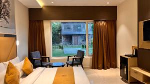 a hotel room with a bed and a window at Hill Turn Corbett in Rāmnagar