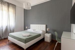 a bedroom with a white bed and a chair at Room & Breakfast D'Annunzio in Ravenna