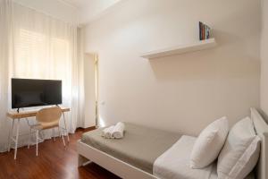 a bedroom with a bed and a desk with a television at Room & Breakfast D'Annunzio in Ravenna