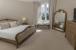 a bedroom with a large bed and a mirror at Walworth Castle Hotel, BW Signature Collection in Darlington