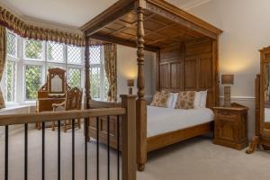 a bedroom with a canopy bed and a desk at Walworth Castle Hotel, BW Signature Collection in Darlington
