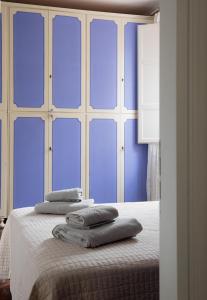 a blue room with a bed with towels on it at Cristallo apartment in Ravenna