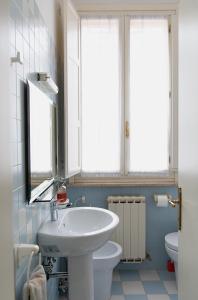 a bathroom with a sink and a toilet and windows at Cristallo apartment in Ravenna