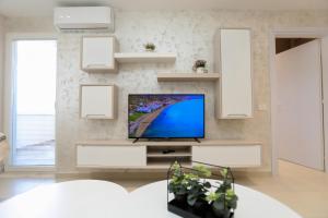 a living room with a flat screen tv on a wall at Alrei Apartment in Vlorë