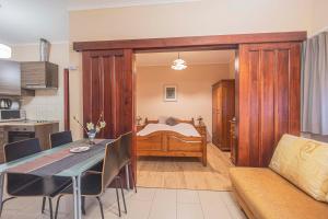 a living room with a bed and a dining table at Besenyei Apartman in Sárvár