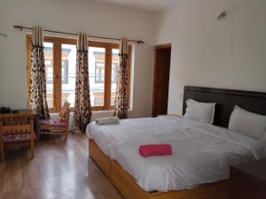 a bedroom with a large bed with a red pillow on it at Stendel Villa Fort Road, Leh in Leh