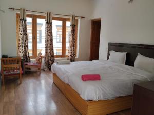 a bedroom with a large bed with a red towel on it at Stendel Villa Fort Road, Leh in Leh +7 photos