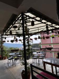 a patio with tables and chairs and a view of the mountains at Berg House Cafe and Hotel in Nagarkot +45 photos