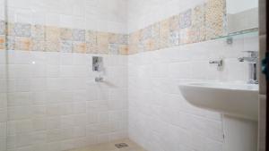 a white bathroom with a sink and a toilet at A One Resort in Negombo