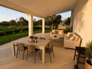 a patio with a wooden table and chairs at Tenuta Saracena in Ostuni