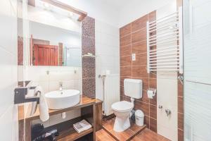 a bathroom with a white toilet and a sink at Besenyei Apartman in Sárvár +12 photos