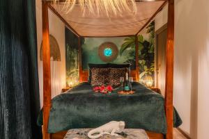 a bedroom with a canopy bed with flowers on it at Lodge de la Jungle avec Spa in Nanteuil-lès-Meaux +52 photos