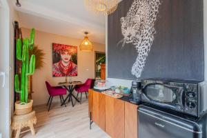 a kitchen with a microwave and a table with chairs at Lodge de la Jungle avec Spa in Nanteuil-lès-Meaux