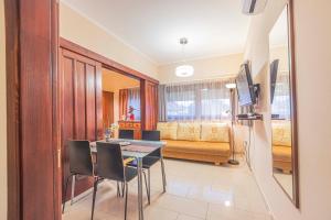a dining room with a table and chairs and a living room at Besenyei Apartman in Sárvár