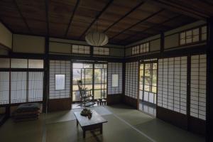 an empty room with a table and windows at 旧雨今雨 in Onomichi