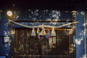 a door with a rope with bells hanging from it at 旧雨今雨 in Onomichi