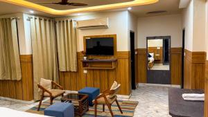 a living room with a couch and chairs and a television at Sumitra Enclave in Jaipur