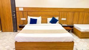 a bedroom with two beds with blue pillows at Sumitra Enclave in Jaipur +11 photos