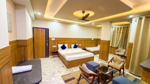 a hotel room with a bedroom with a bed and chairs at Sumitra Enclave in Jaipur