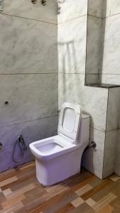 a bathroom with a toilet with a mirror on the wall at Sumitra Enclave in Jaipur