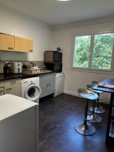 a kitchen with a washing machine and a table and chairs at Escale Rennes in Rennes