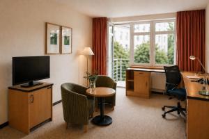 a hotel room with a desk and a television at Hotel Am Weberplatz in Dresden