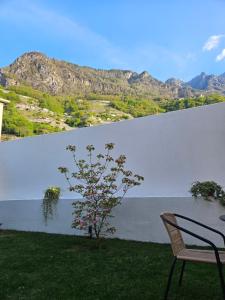 a table and a chair in front of a large wall at La Cereria INES in Chiavenna