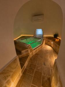 a pool in the middle of a room with a tile floor at Tenuta Saracena in Ostuni