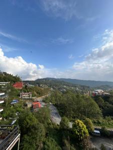 a view of a city with a road and trees at Berg House Cafe and Hotel in Nagarkot
