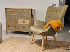 a chair with a yellow blanket on it next to a dresser at La Cereria INES in Chiavenna +6 photos
