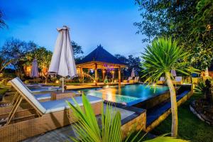 a pool at a resort with an umbrella at Sunset Garden Nusa Lembongan in Nusa Lembongan