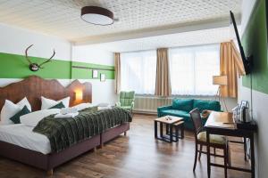 a bedroom with a bed and a living room at "Landidyll"Hotel Rathaus in Wildemann