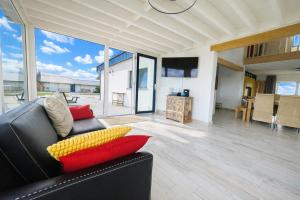ein Wohnzimmer mit einem schwarzen Sofa und roten und gelben Kissen in der Unterkunft Villa Intensity in Bastogne