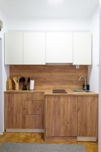 a kitchen with wooden cabinets and a sink at Apartman Gorica in Priboj