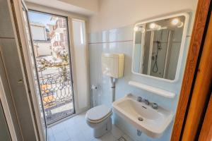 a bathroom with a sink and a toilet and a window at Albergo Osteria Leso1815 in Bosco Chiesanuova