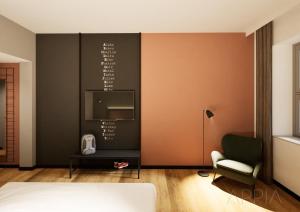 a bedroom with a bed and a tv on a wall at Essential by Dorint Mannheim Taylor Park in Mannheim