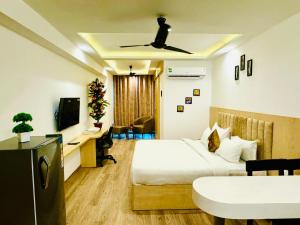 a hotel room with a bed and a desk and a tv at Golden Studio With Swimming pool in Jaipur