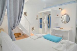 a white room with a bed and a staircase at Seafis Boathouse Klima in Klima