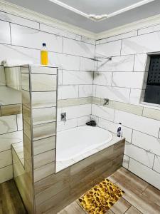 a white bathroom with a tub in a room at Kingdoms Place Guesthouse in Ga-Luka +68 photos