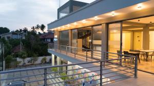 a balcony of a house with glass doors and a table at A One Resort in Negombo