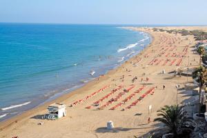 a beach with a lot of people and the ocean at RT-Green Park in Playa del Ingles