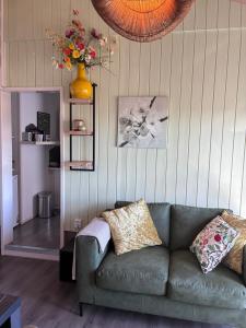 a living room with a couch and a vase of flowers at Appels en Peren Bed and Breakfast in Breezand